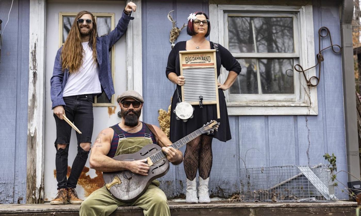 Bandmates from Reverend Peyton's Big Damn Band pose with their musical instruments.