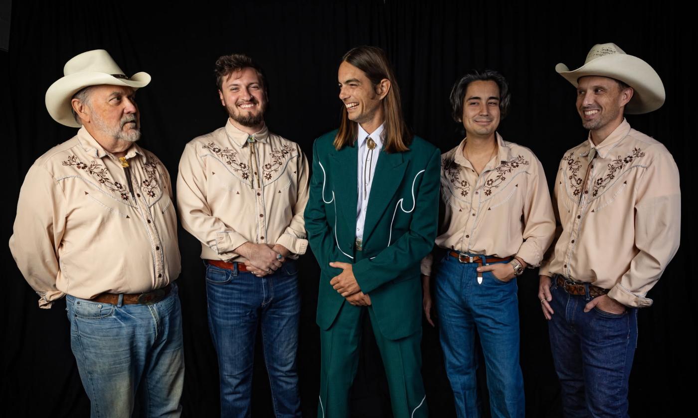 The five members of Brett Staska and the Souvenirs standing in their country music outifits