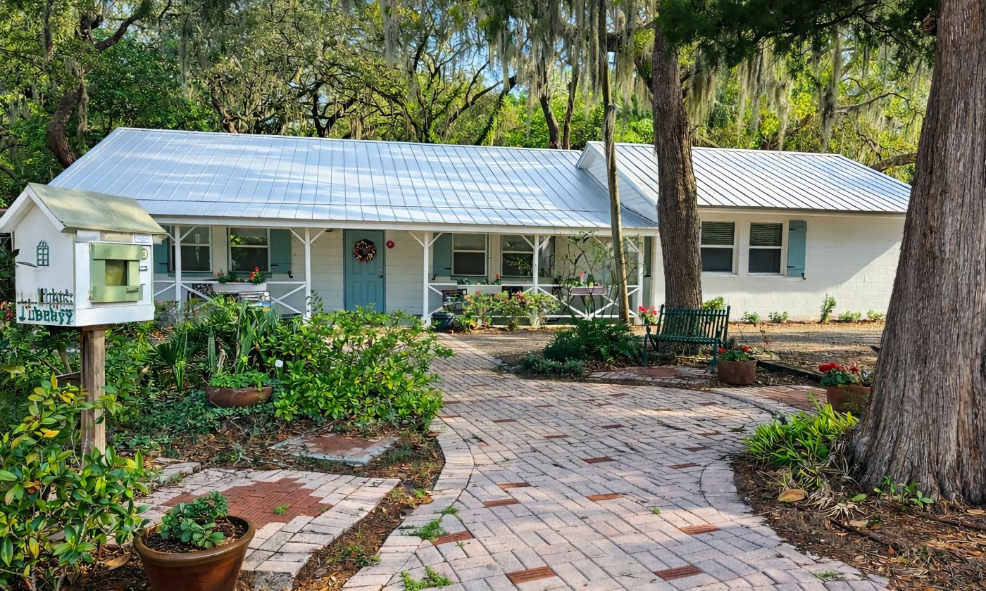 The exterior of the Garden Club of St. Augustine, a low white ranch house on a landscapped lot