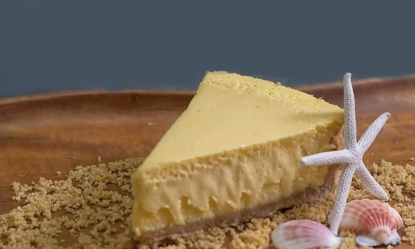 A slice of key lime pie on a bed of graham cracker crumbs