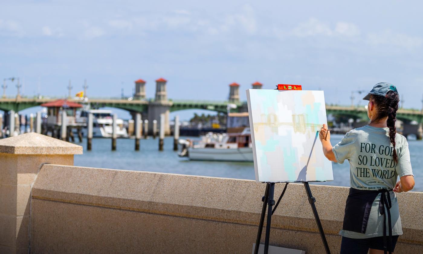 An artist painting the Bridge of Lions outside