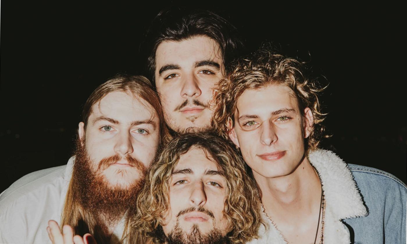 The band Magi standing with heads together