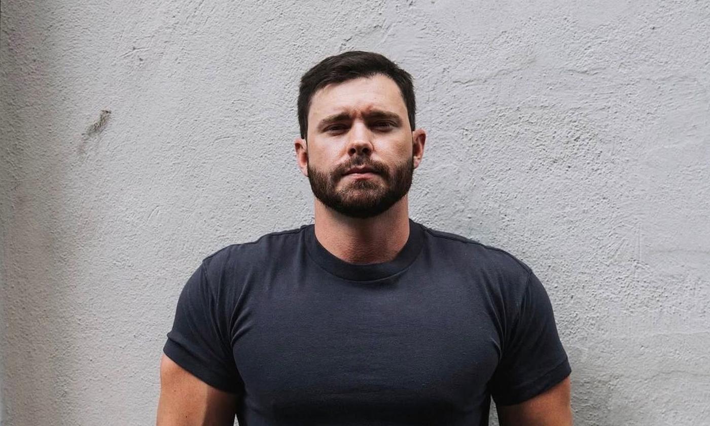 Songwriter Murphy Elmore standing in front of white wall