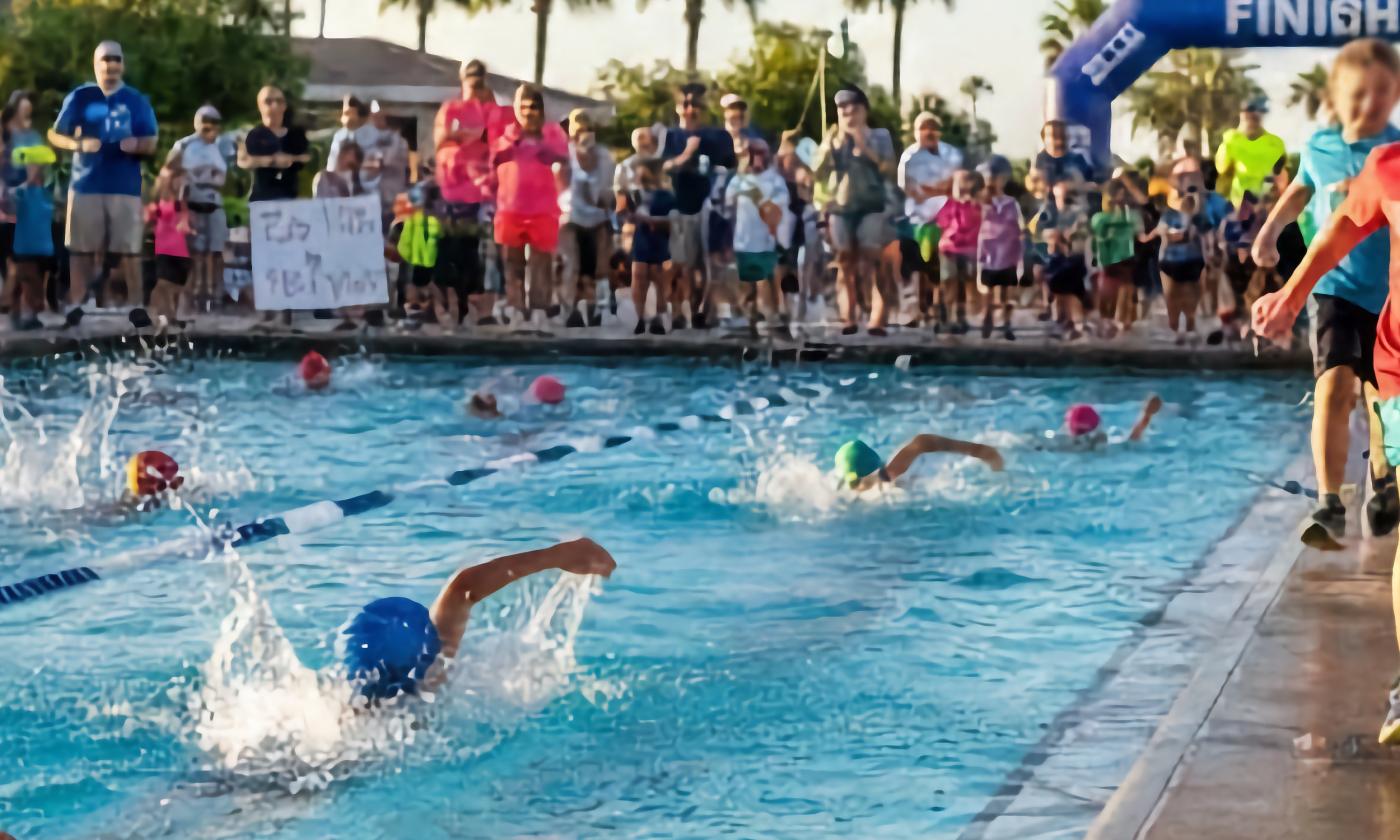 Swimmers and runners participating in a kid's triathalon