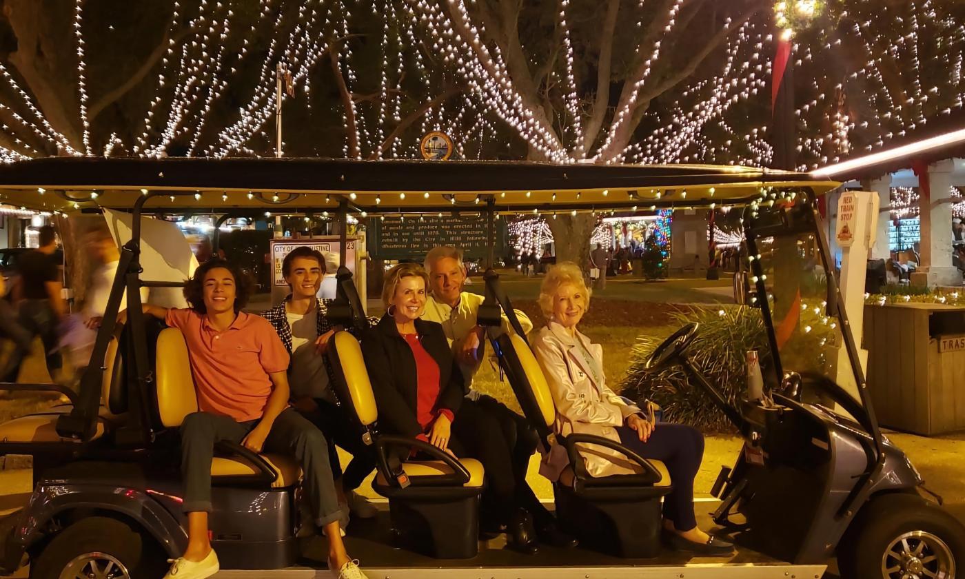 A Gold Tours electric EV with a family aboard for a Nights of Lights Tour