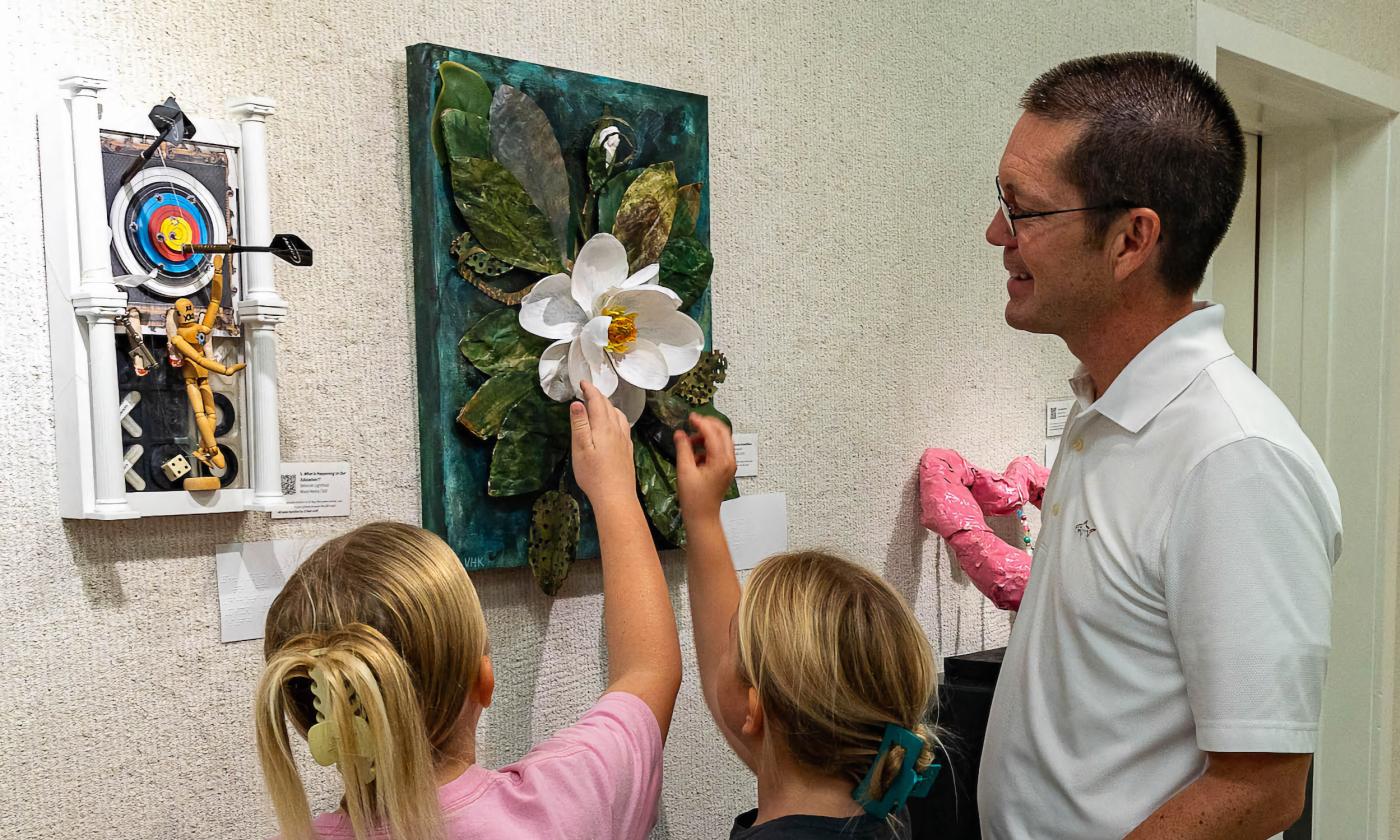 Visitors touching an art piece
