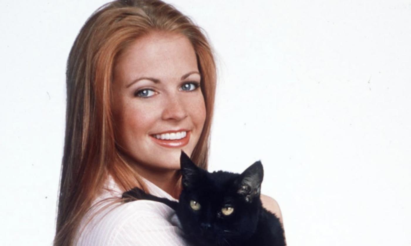 Sabrina the Teenage Witch smiles while holding Salem.