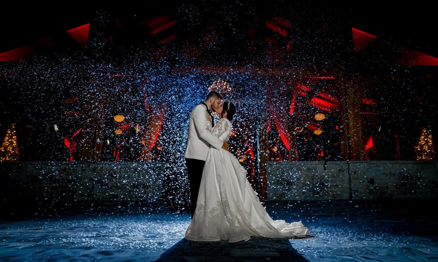 A bride and groom kissing on the dance floor