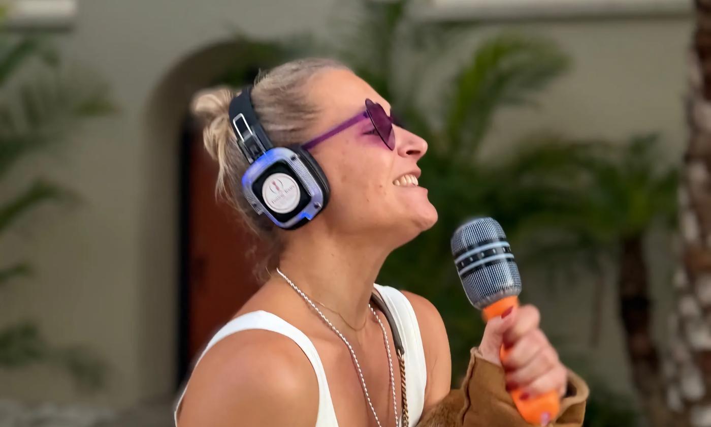 A woman with disco headphones and a microphone walking in St. Augsutine