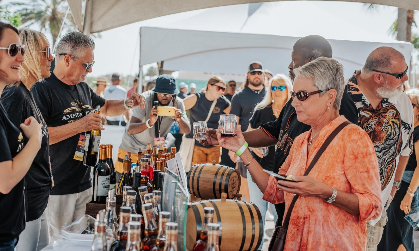 A woman getting a sample of whiskey at a food festival