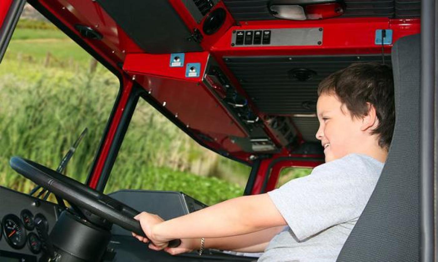 A child sitting front seat in a firetruck