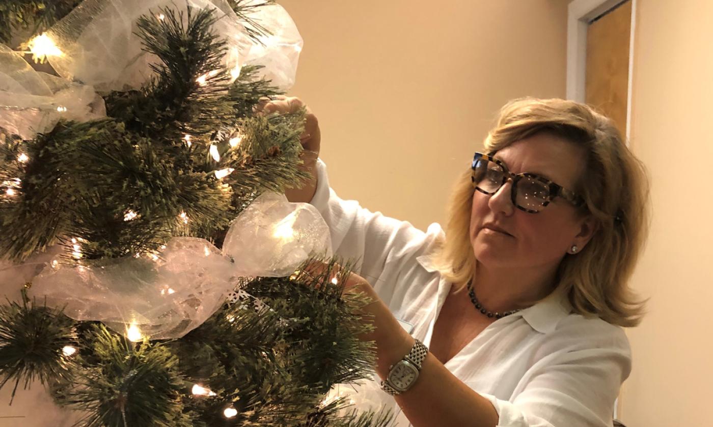 A volunteer decorates a Christmas tree to be enjoyed and auctioned for charity at the Festival of Trees in the Lightner Museum in St. Augustine.