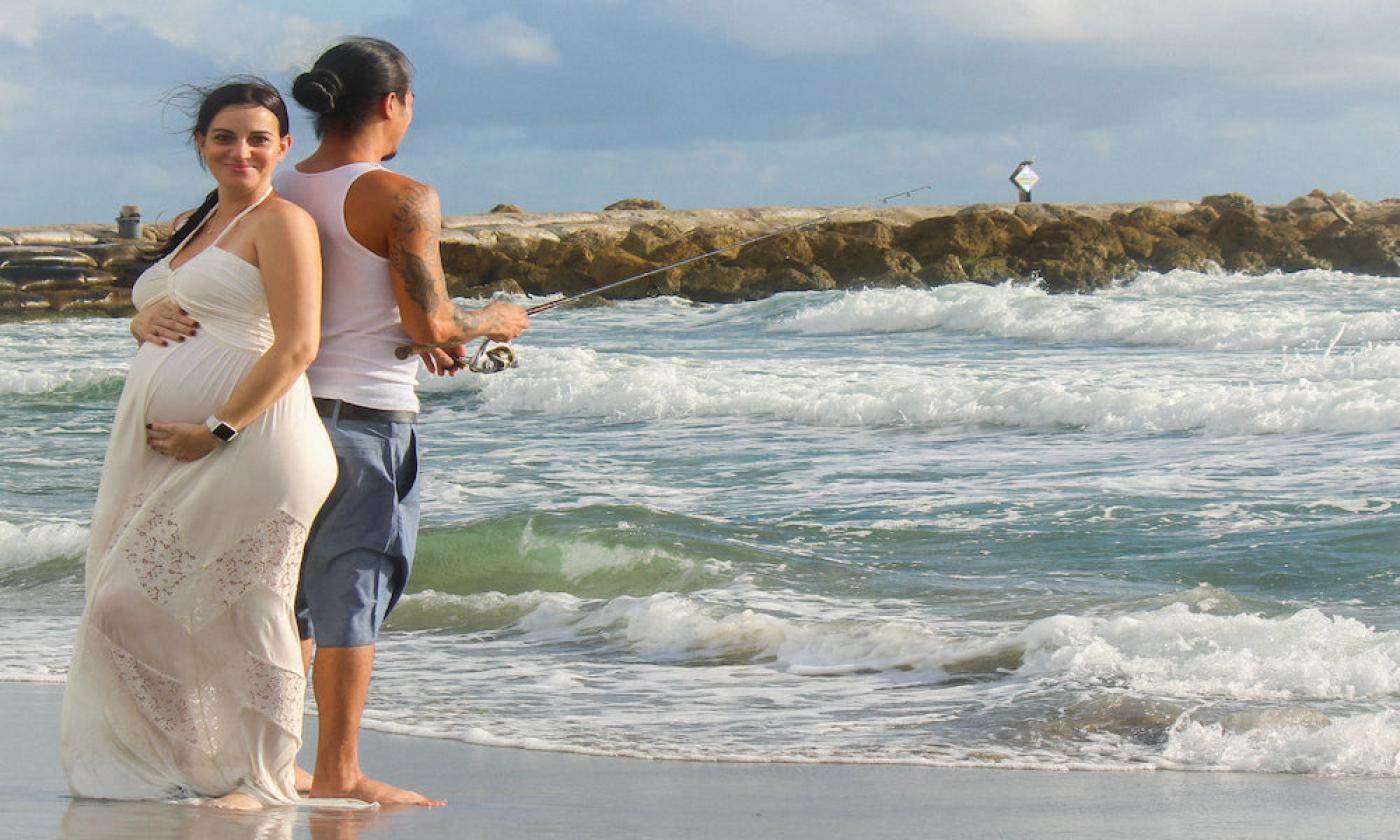 A couple fishes at the beach together