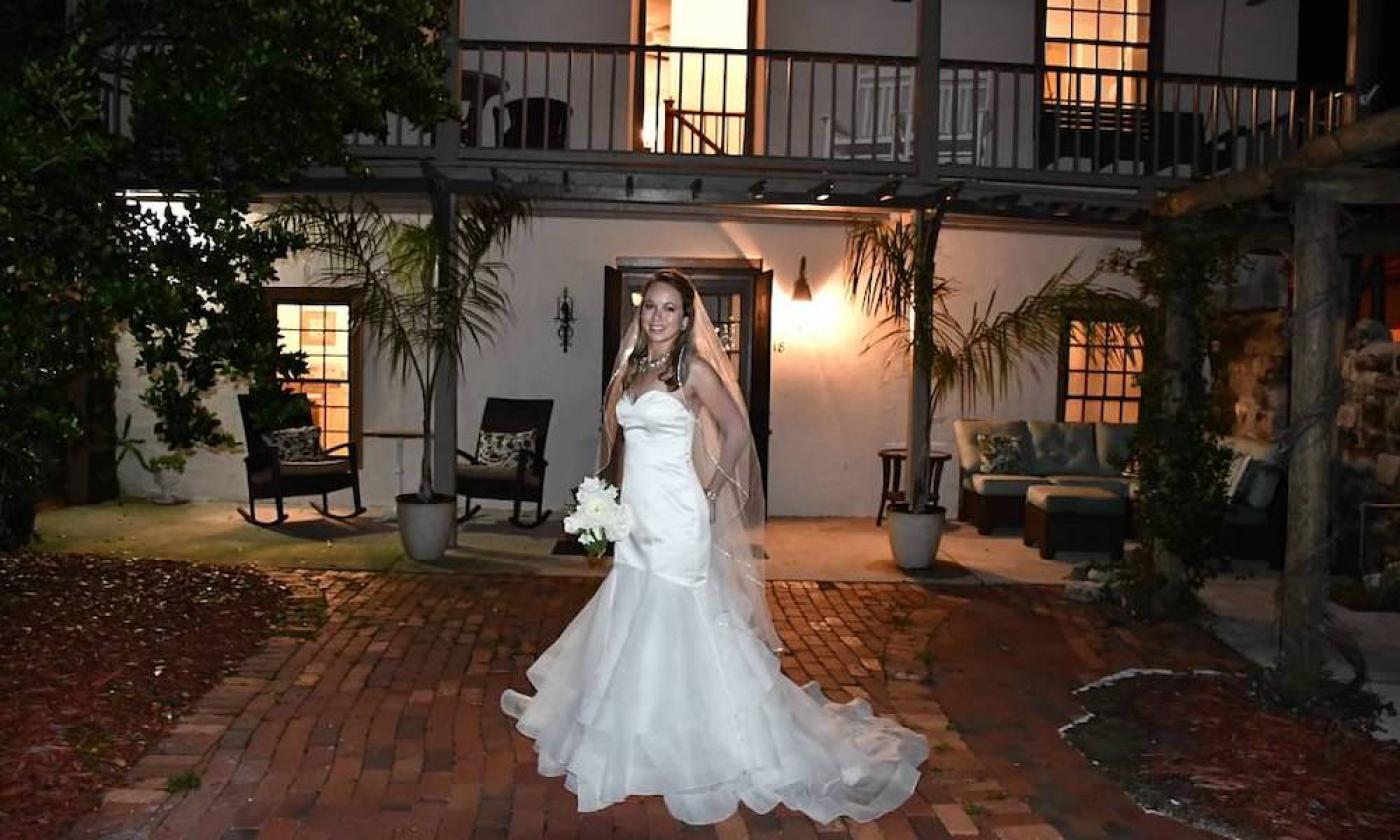 A bride taking photos in the Sanchez House courtyard