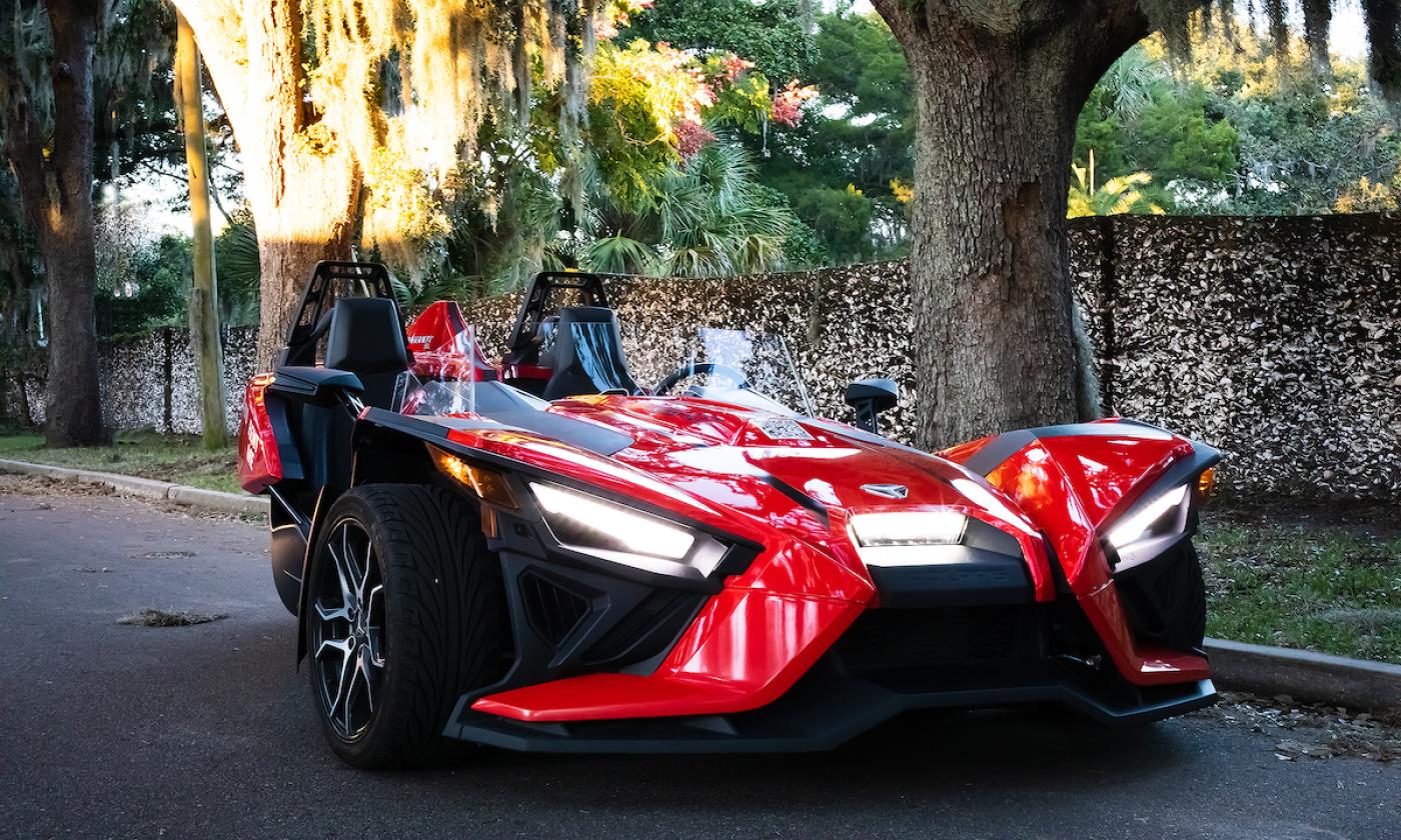 A red slingshot vehicle in St. Augustine and is available for rent at Seaside Slingshots.