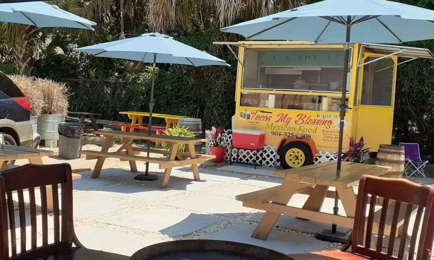 Outside seating and umbrellas in front of Taco My Blessing in St. Augustine