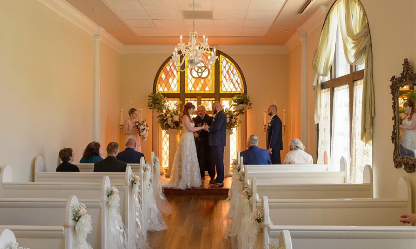 A private wedding at the small and lovely Amore Chapel, with a few guests in the front pews and bride, goorm, and officiant at the front