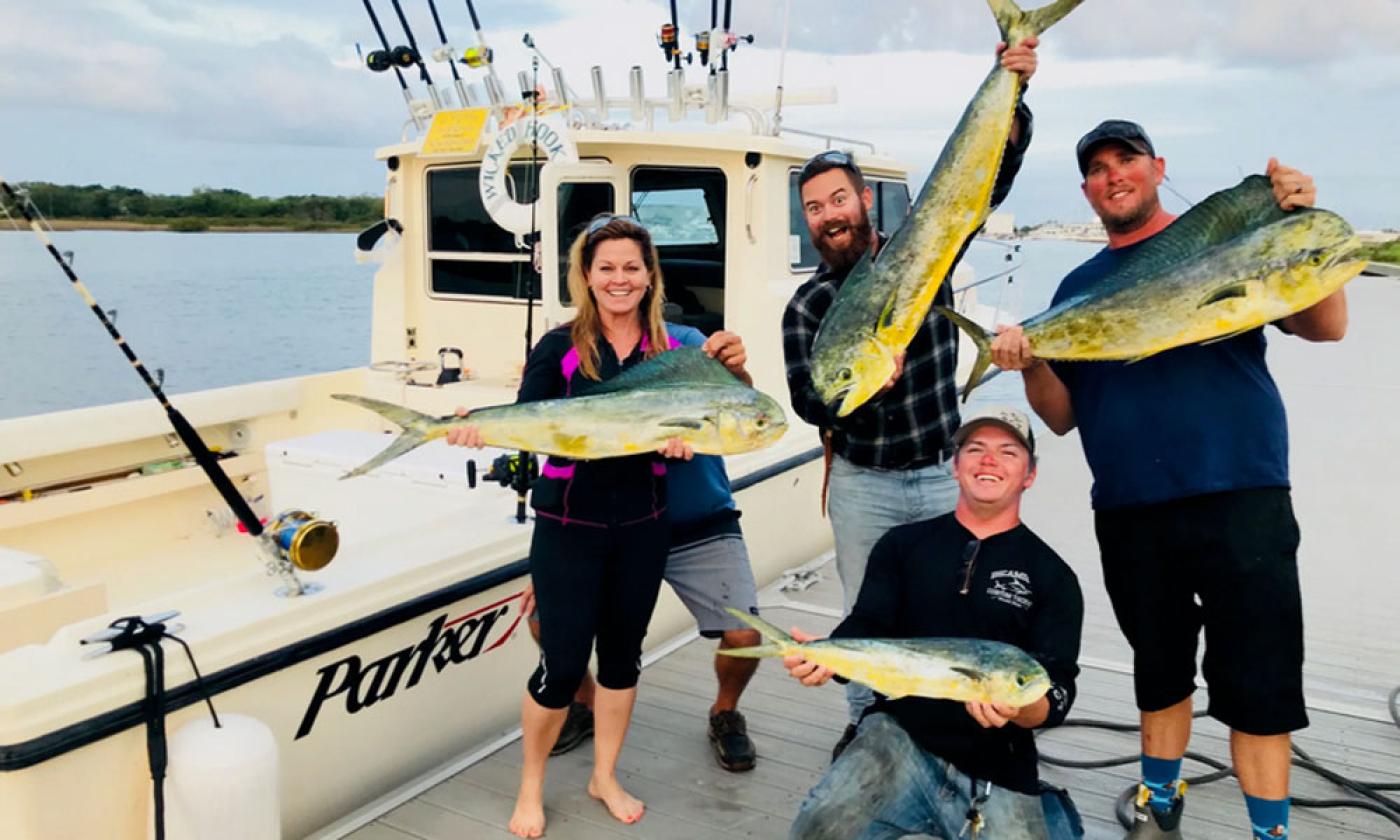 The happy captain, crew, and fishermen aboard Wicked Hooker Fishing Charters.