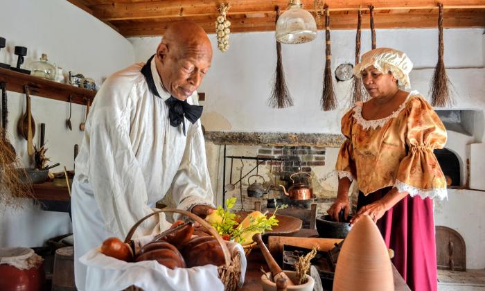 Two actors portraying servants from the past in the kitchen of the Ximenez-Fatio House Museum