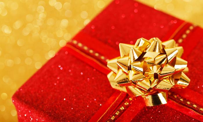 A Christmas gift is wrapped with a golden bow. 