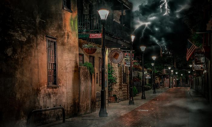 A photo of Hypolita Street with lanterns lit under a cloudy sky