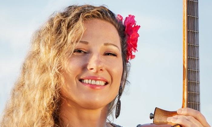 Female musician Yael Dray, smiling, in St. Augustine, Florida with guitar.