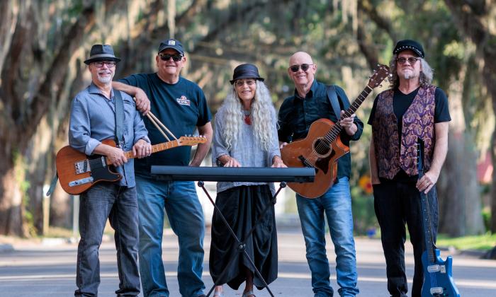 The five-person group, John Dickie and the Collapsible B, standing on Magnolia St. in St. Augustine, holding their instruments or drum sticks