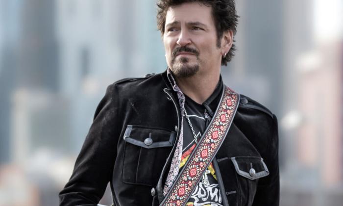 Mike Zito poses in front of a blurred background.