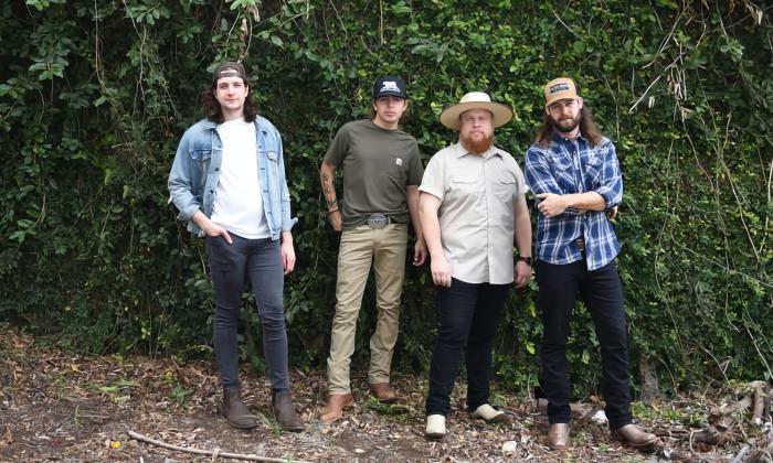 The four members of Cumberland, standing outside near trees