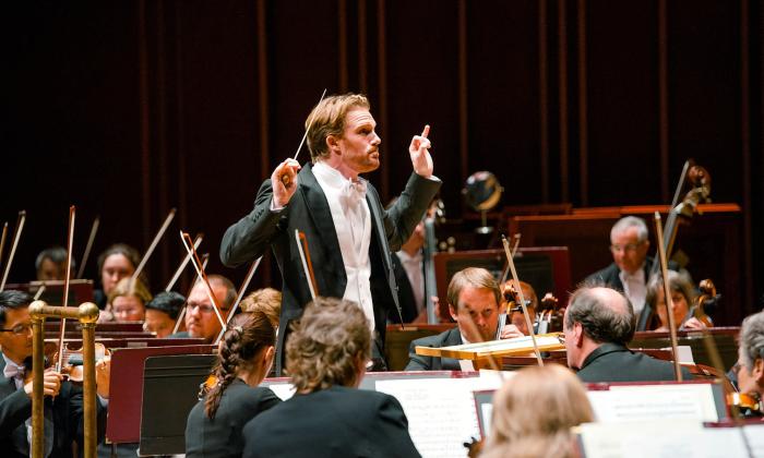The conductor of the Jacksonville Symphony Orchestra and members of the string section during a concert