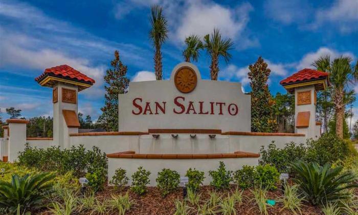 Entrance sign of San Salito featuring a Mediterranean architectural style with red tile accents