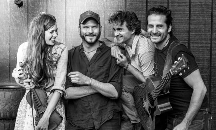 Bandmates from the Adam Ezra Group smile and pose in a black and white photograph.