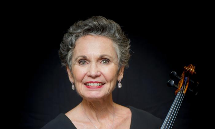 Glynda Newton, with her violin against a black background