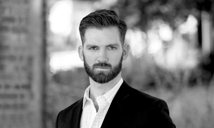 Baritone singer, John Daugherty standing outside in black and white