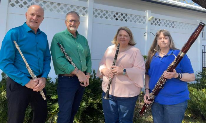 The four members of the 9B Woodwind Quartet standing outside with their instruments