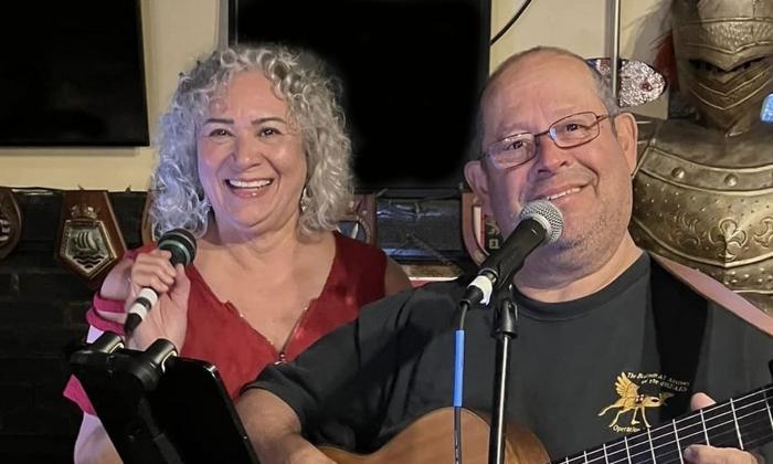 musicians Millie and Galin on stage, with microphone and guitar 