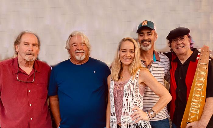 Group image of the band The Palmetto Pickers, standing in front of a white wall. 