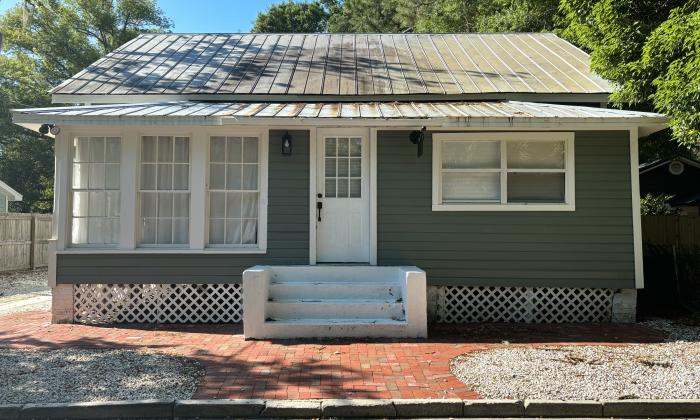111 Lincoln Street. One-story green slatboard house with brick path out front.