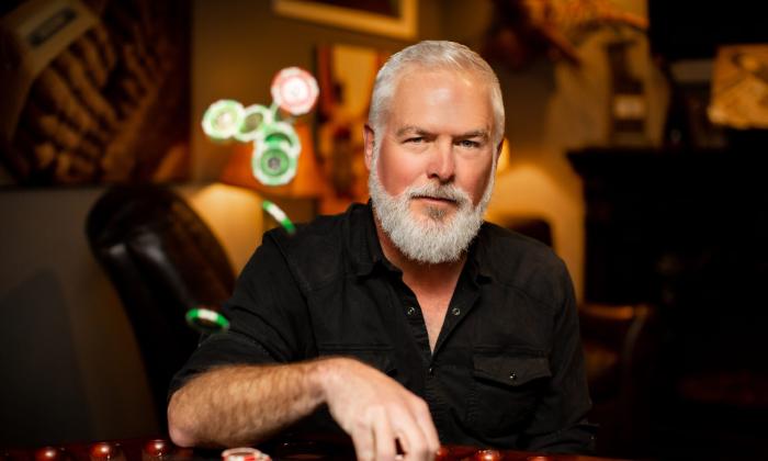 Rivers Rutherford in a darkened room, wearing a black shirt