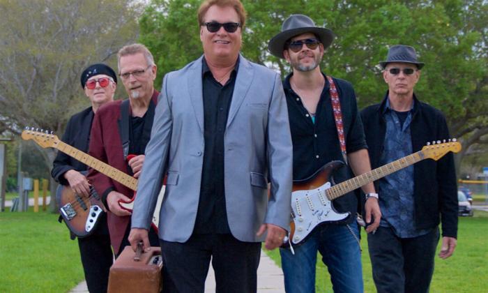 Bandmates from the Backtrack Blues Band smile and pose with their guitars.