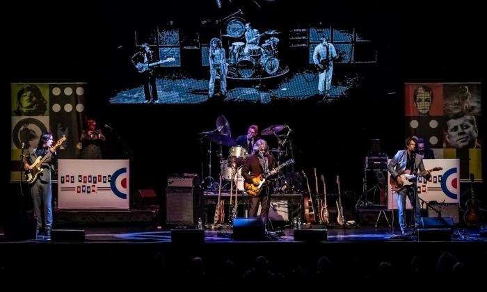 Bandmates from The Sixties Show perform live on stage.