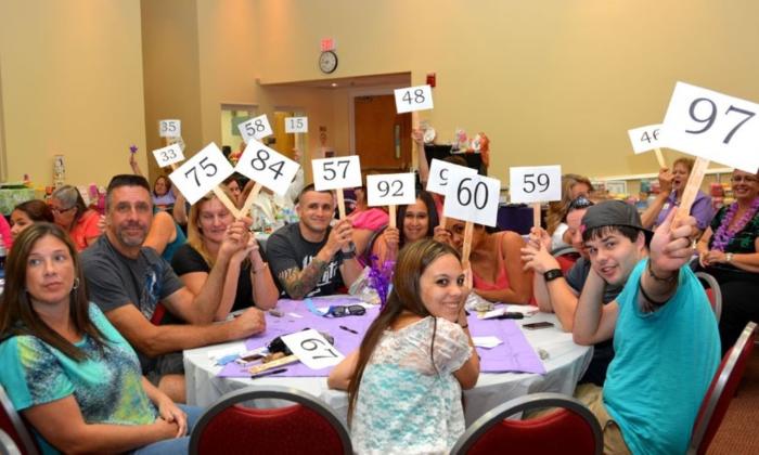 Bidders smile and hold up their paddles.