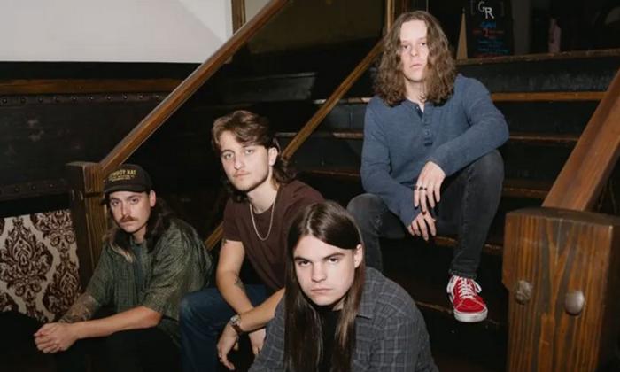 Four members of the alt-rock band Lightwatch sitting on stairs