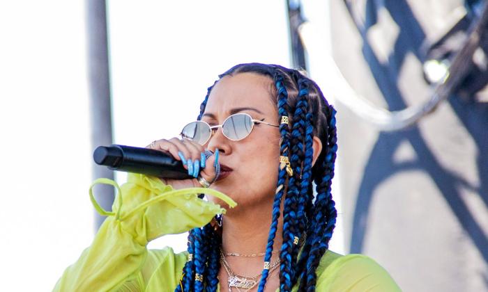singer Eli-Mac (in sunglasses) onstage outside, holding microphone