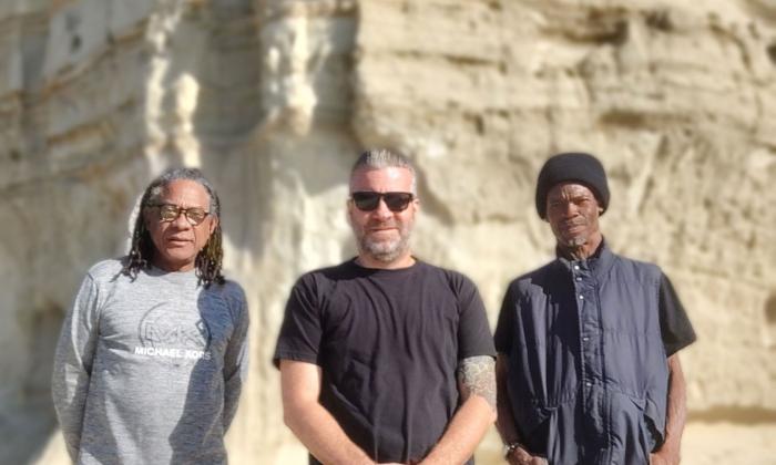 The band Part One Tribe standing in front of a white natural rock formation