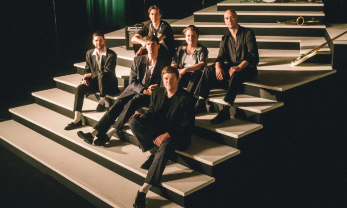 Bandmates from The Dip smile and pose on a staircase.