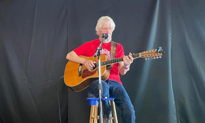 Bob Patterson on an outdoor stage with a black backdrop