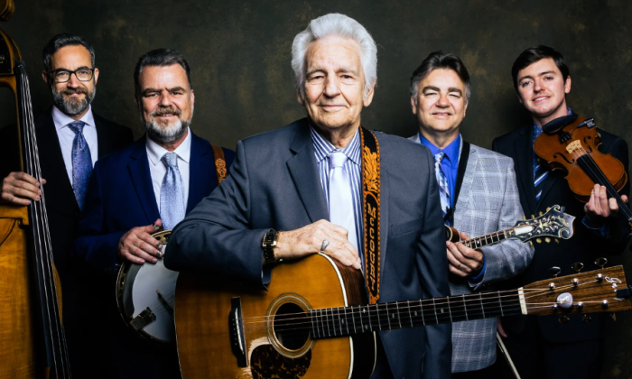 Bandmates from the Del McCoury Band pose in front of a textured backdrop.