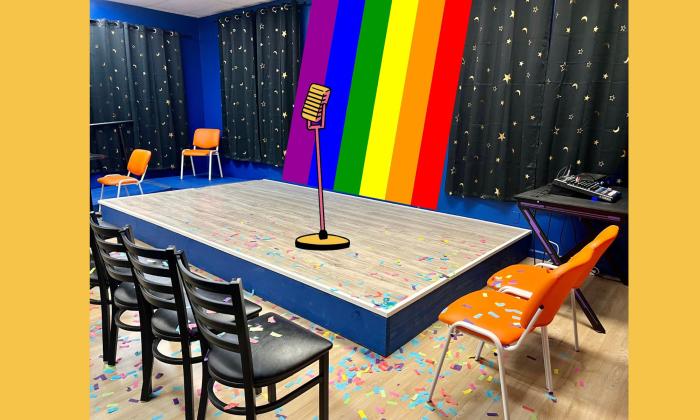 a mic on a stage in front of a rainbow