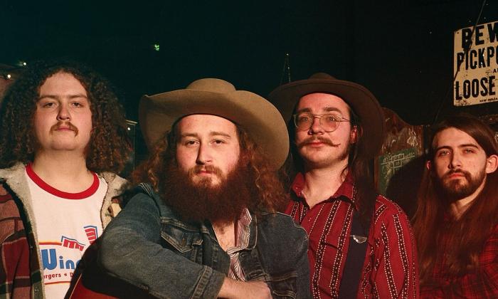 Four members of the band Mojohand, standing together